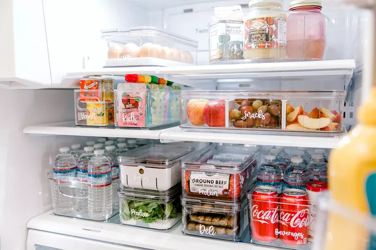 organized fridge with clear bins and storage containers in a small kitchen
